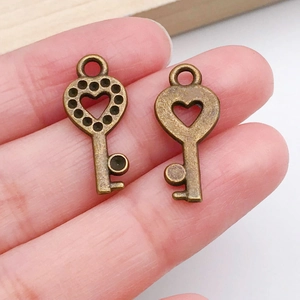 Macro shot of two vintage bronze heart key pendants for DIY jewelry making and crafts