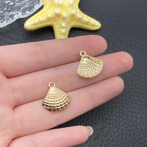 Vue détaillée de deux breloques en forme de coquille dorée pour bijoux faits main