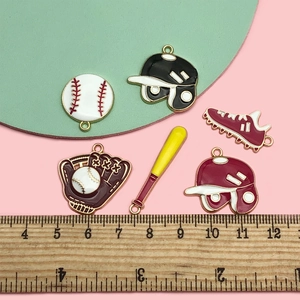 Macro view of alloy enamel baseball charms including bat, glove and helmet on colorful background