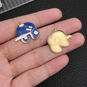 Detailed view of double-sided baseball cap charms with blue enamel and golden texture