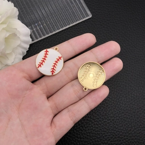 Detailed macro view of enamel baseball charms with red stitching and golden metal back