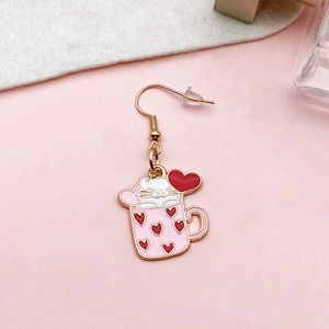 Detail of cartoon cat in a pink mug pendant with heart patterns and gold earring hook