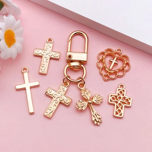 Primer plano de colgantes de cruz dorados con motivos de filigrana para accesorios de joyería