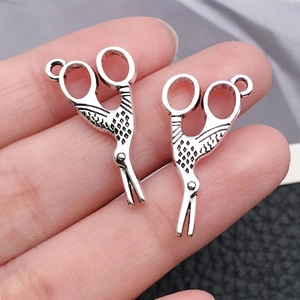 Dettaglio di mini ciondoli a forma di forbici in argento antico per gioielli DIY