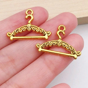 Close-up of golden metal clothes hanger charms with vintage hollowed floral patterns