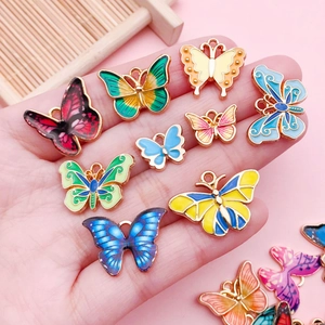 Vista macro de colgantes de mariposa de esmalte colorido en varios tamaños para joyería DIY