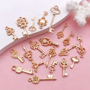 Mix van 20 roségouden sleutelhangers voor DIY sieraden op een roze achtergrond