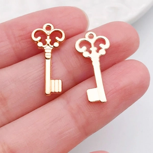Handheld weergave van vintage gouden sleutelhangers voor DIY-sieraden en maatreferentie