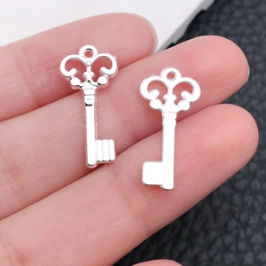 Detailed macro of vintage silver heart key pendants with intricate baroque openwork design