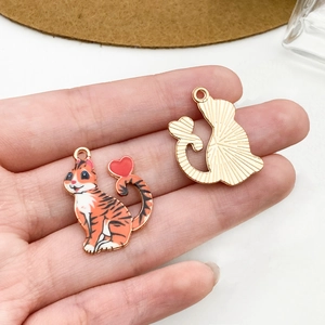 Dettagli dei ciondoli gatto tigrato con coda a cuore e retro in metallo dorato
