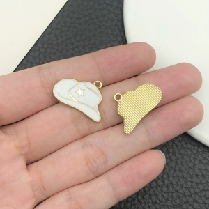 Dettaglio del ciondolo a cappello da cowboy in smalto bianco con stella d'oro per gioielli