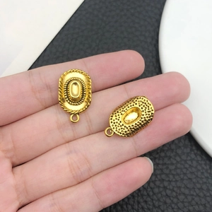 Dettaglio di ciondoli ovali dorati a cappello da cowboy con trama a corda per gioielli DIY