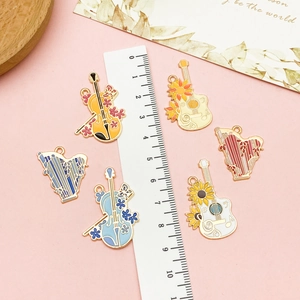 Macro shot of musical instrument charms with ruler showing 3cm to 4cm dimensions