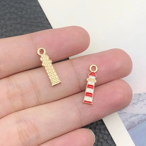 Macro shot of gold and red-white enamel lighthouse charms for DIY jewelry making