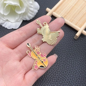 Detail of yellow cello enamel pendant with pink cherry blossoms and golden back