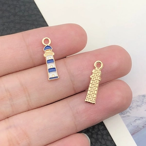 Macro shot of blue and white enamel lighthouse charm showing front and textured back view