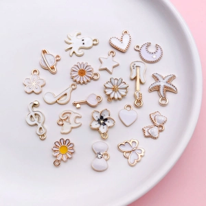Close-up of assorted white enamel charms in moon and star shapes for DIY jewelry making