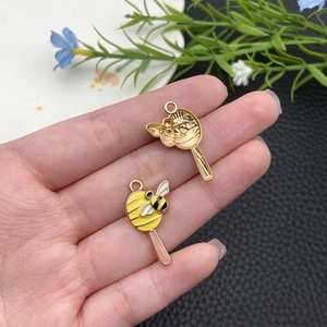 Détail macro du pendentif sucette abeille avec finition émail jaune et noir sur métal