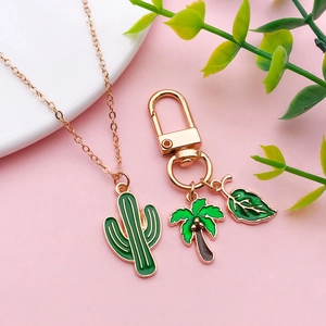 Pendentifs cactus et feuilles verts sur chaînes dorées pour bijoux DIY sur fond rose