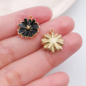 Macro detail showing front black enamel daisy charm and textured metal back with ring