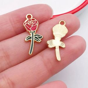 Detail of rose charm showing oil-dripping flower front and textured metal back
