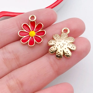 Macro detail of red enamel daisy flower alloy pendant showing front and textured back
