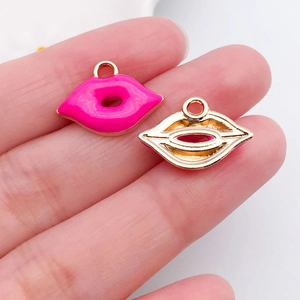 Macrodetail van een roze emaille lippenhanger met vergulde basis voor doe-het-zelf sieraden