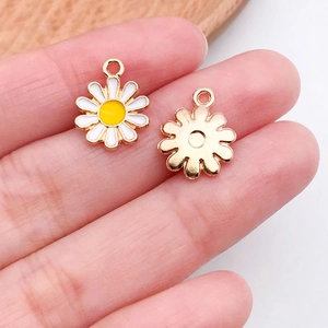 Macro view of tiny daisy enamel alloy charms with gold edges for DIY jewelry making