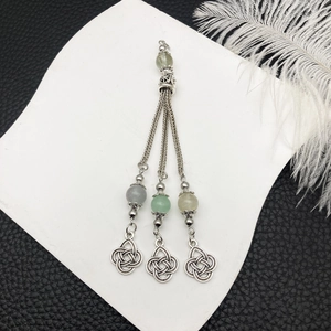 Dettaglio di ciondolo a nappa argento vintage con perle colorate e nodi celtici