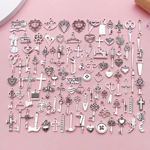 Flat lay of vintage silver alloy charms featuring sewing machine and tool shapes for DIY jewelry