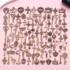 Flat lay of vintage bronze alloy DIY charms featuring assorted religious and craft motifs