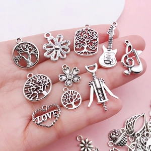 Close-up of vintage silver alloy charms including tree of life and heart for DIY jewelry