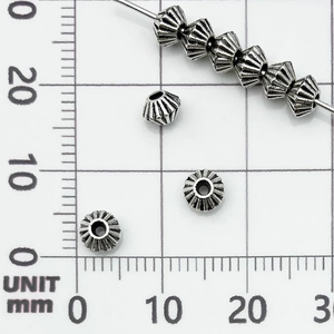 Vista macro di perline distanziatrici in argento vintage con motivo a sole per gioielli