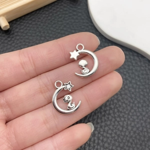Vista macro de colgantes de luna y serpiente plateados para joyería DIY y collares