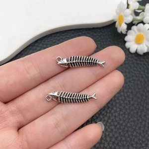 Gros plan de deux pendentifs arêtes de poisson argent antique pour création de bijoux