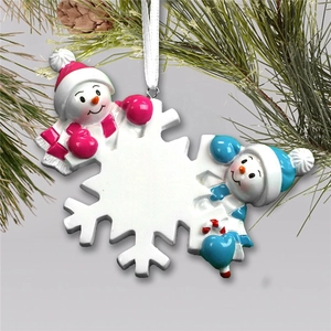 Close-up of snowflake resin ornament with two snowmen and blank space for writing