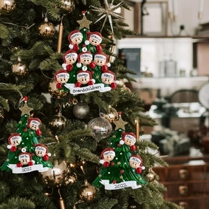 Close-up of personalized green Christmas tree ornaments featuring 2024 grandchildren names