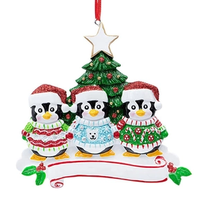 Detailed view of three resin penguins in sweaters with customizable banners for Christmas