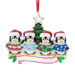 Christmas tree ornament featuring a family of four penguins in festive sweaters with a banner