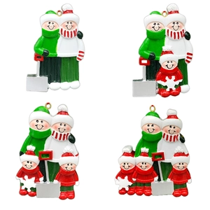 Detail of hand-painted resin family sleigh Christmas ornaments with shovels and gold loops