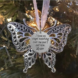 Memorial butterfly ornament with inscribed angel quote hanging on a festive Christmas tree