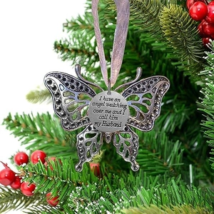 Macro detail of memorial silver butterfly ornament for husband on Christmas tree
