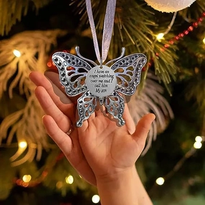 Silver angel wing butterfly ornament with memorial text hanging on a Christmas tree