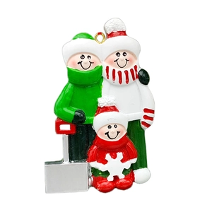 Macro detail of hand-painted resin Christmas family ornament with three figures on a sled