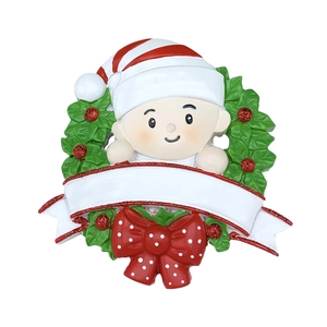 Détail d'ornement bébé de Noël avec couronne de houx et bannière pour personnalisation