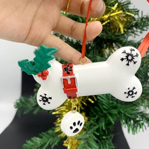 Detail of dog bone Christmas ornament with red collar motif and paw print pendant