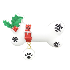 Detailed resin dog bone ornament featuring green holly leaves and a black paw print tag