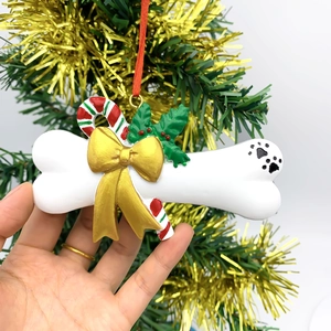 DIY bone-shaped Christmas tree ornament with golden bow and holly leaves for pets