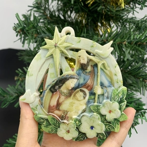 Close-up of a circular nativity scene ornament featuring the Holy Family and star details