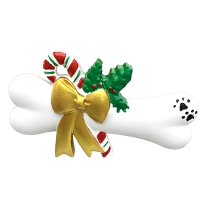 Detail of resin Christmas dog bone ornament with golden bow and holly leaves